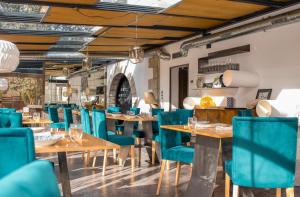un restaurante con mesas de madera y sillas azules en Box Art Hotel - La Torre en Collado Mediano