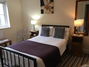 a bedroom with a large bed with two lamps on tables at Turi House in Canterbury