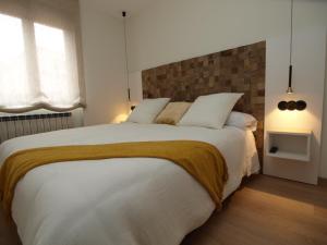 - une chambre avec un grand lit blanc et 2 oreillers dans l'établissement Apartamentos m.bell, à León