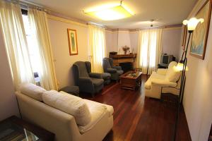 sala de estar con sofá blanco y sillas en Casa Suarna en Navia de Suarna