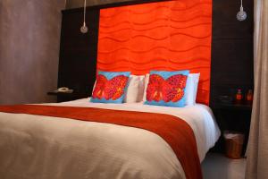 a bedroom with a large bed with an orange headboard at Casa Lunatta in Guanajuato