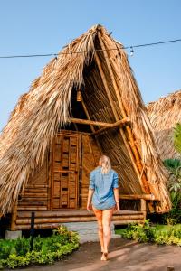 a woman standing on top of a wooden bench at Tiki Hut Hostel in Palomino