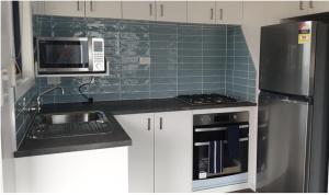 a kitchen with a sink and a microwave at Beachcomber Holiday Park in Potato Point