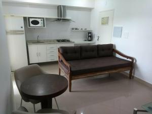 a living room with a couch and a table and a kitchen at Domus Angelis in Cachoeira Paulista