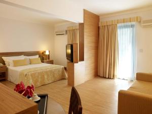 a hotel room with a bed and a television at Hotel Nacional Inn Cambuí Campinas Residence in Campinas