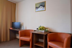 a room with two chairs and a desk with a television at Arka Kraków in Krakow