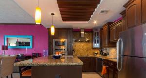 a kitchen with pink walls and a refrigerator at Sonoran Sky 3BR 1202 UpperSkyby Casago in Puerto Peñasco