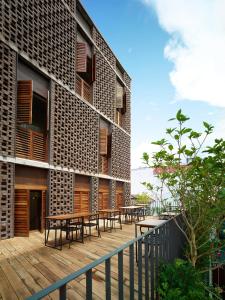 a building with tables and chairs on a wooden deck at Lantern Hotel in Kuala Lumpur
