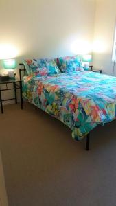 a bedroom with a bed with a colorful comforter at Middle Ridge, Toowoomba, in Toowoomba