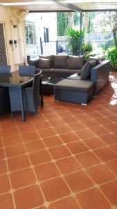 a patio with a couch and tables and chairs at Middle Ridge, Toowoomba, in Toowoomba