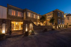 una casa grande con luces en una calle por la noche en Alacati Kostem Hotel - Special Category, en Alacati