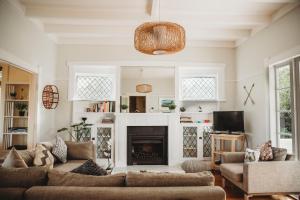 uma sala de estar com dois sofás e uma lareira em Island Villa- Waiheke Escapes em Oneroa