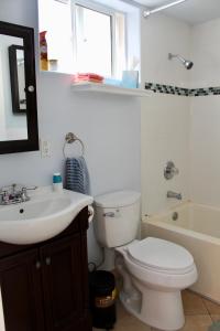 a bathroom with a toilet and a sink and a tub at Sweet Dreams B&B LA in Sherman Oaks