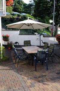 a table and chairs with an umbrella on a patio at Gästehaus Petra in Ürzig