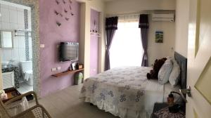 a bedroom with a bed and a tv and a window at Remember Sea View B&B in Huxi