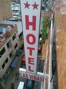 a sign for a hotel on a city street at Hotel Las Viñas in Huánuco