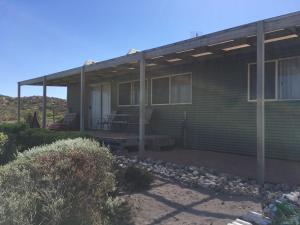 a house with a large porch with a patio at Private Beach Cottage At Ecostays in Greenough