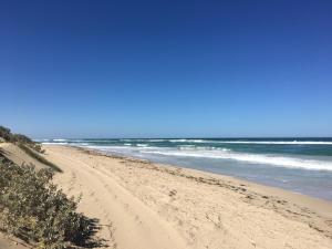 a sandy beach with the ocean in the background at Private Beach Cottage At Ecostays in Greenough