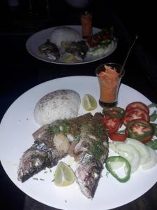 a plate of food with fish and vegetables on a table at Hostal Pachamama in Isla de Cañas