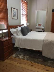 a bedroom with a bed with white sheets and pillows at La Dentella- Terrace on Bentinck Street in Bathurst