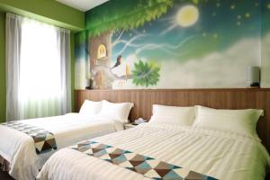 two beds in a room with a painting on the wall at MUSHROOM30 in Taitung City