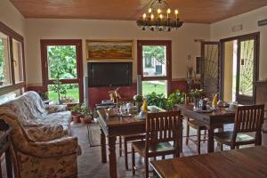 a living room with tables and chairs and a tv at Agriturismo Cascina Madonnina in Pregnana Milanese