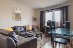 a living room with a couch and a table at 4 Bedroom Apartment By Sensational Stay Short Lets & Serviced Accommodation, Aberdeen , Roslin Street With Free Wi-fi & Netflix in Aberdeen