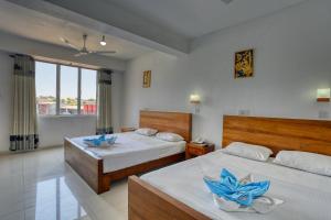 a bedroom with two beds with blue flowers on them at Hotel Sea Line in Galle