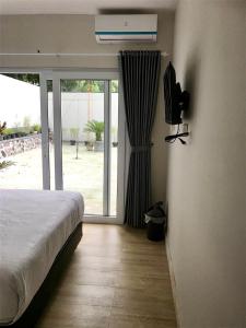 a bedroom with a bed and a tv and a window at Omah SunFlower in Yogyakarta +34 photos