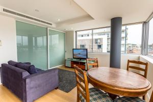 a living room with a table and a couch at Honeysuckle Executive Suites in Newcastle