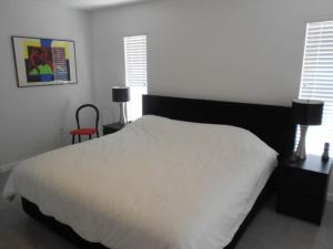 a bedroom with a white bed and a red chair at Foxrun Retreat - 3BR Inverness Poolhome in Inverness