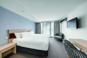 a hotel room with a bed and a tv at Central Studio Hotel Sydney in Sydney