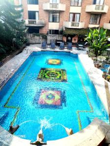 a swimming pool in front of a building at Hotel Manaslu in Kathmandu