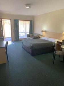 a hotel room with a bed and a desk at Arthur Phillip Motor Inn in Cowes