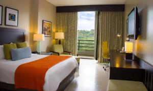 a hotel room with a bed and a balcony at Summit Rainforest Golf Resort & All Inclusive in Paraíso