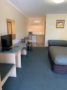 Habitación de hotel con 1 dormitorio con cama y escritorio en Arthur Phillip Motor Inn, en Cowes