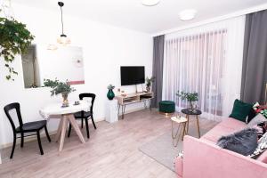 a living room with a pink couch and a table at Apartament Arkadia na Kazimierzu in Kraków