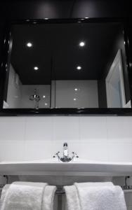 Un baño con lavabo con espejo y toallas. en Supeluse-Strassel Beach Apartment, en Pärnu