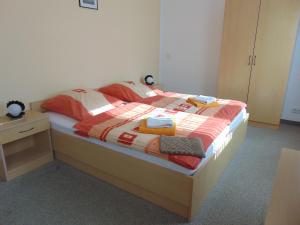 een slaapkamer met een bed met een deken erop bij Pension "Zur Katze" in Gelenau