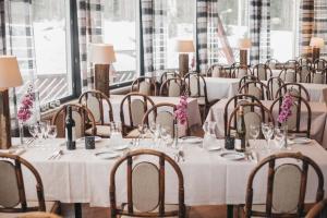 a row of tables with white table cloths and chairs at Revontuli Resort Glass Igloos in Hankasalmi