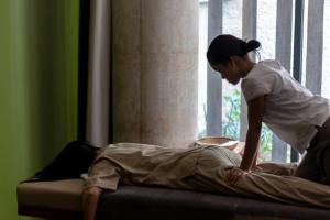 a woman standing over a man on a bed at Penh House Hotel in Phnom Penh