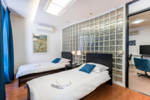 two beds in a room with a glass wall at White&Blue Top Center App in Pula