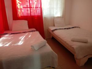 two beds in a small room with a window at Herard share apartamento in Punta Cana