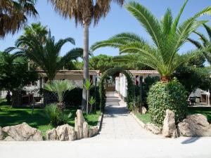 a pathway with palm trees and a building at Kamemi Village & Camping in Ribera