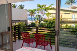 a balcony with red chairs and a view of the ocean at Costa Pacifica Baler in Baler