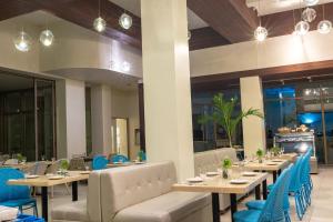 a restaurant with long tables and blue chairs at Costa Pacifica Baler in Baler