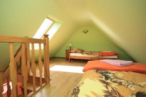 a attic bedroom with a bed and a window at Karpnicka Struga W Dolinie Pałaców i Ogrodów in Jelenia Góra