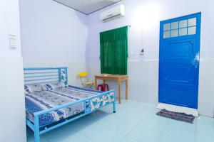 een kamer met een bed en een blauwe deur bij An Loc Motel in Vĩnh Long