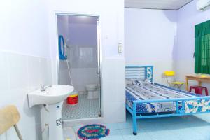 een badkamer met een douche, een wastafel en een toilet bij An Loc Motel in Vĩnh Long