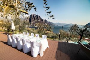 a table with white chairs and a view of the water at Hotel Miranda in Riva di Solto